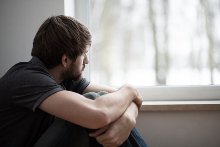 Person sitting alone experiencing depressive symptoms related to bipolar disorder