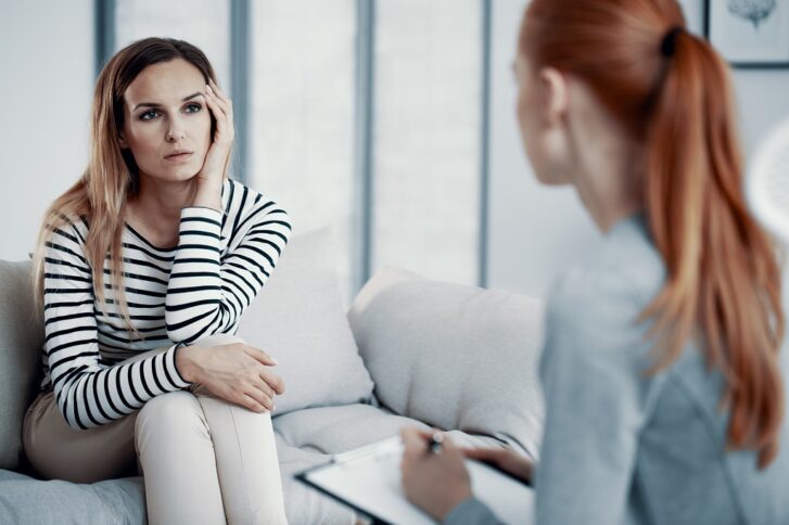 Woman discussing emotional difficulties with a psychologist during a mental health evaluation session